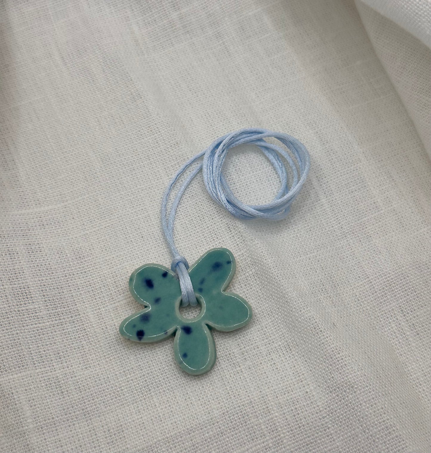 Collier bébé fleur bleu moucheté